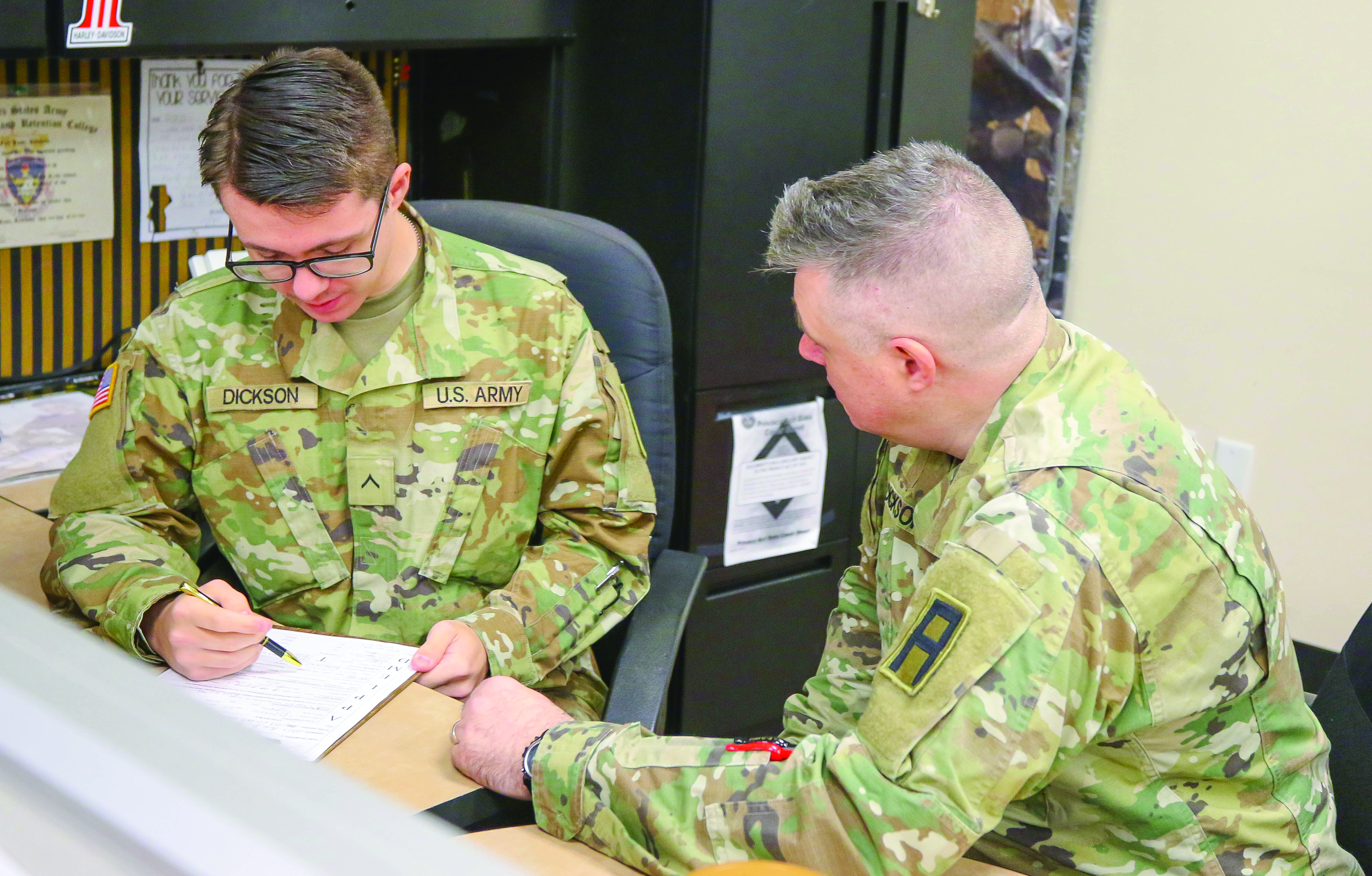 PVT Alexander Dickson (left), a small arms/towed artillery repairer taking part in the U.S. Army’s Hometown Recruiter Assistant Program at the Lacey Recruiting Station in Lacey, WA, discusses his duties with his father, SFC Nathan Dickson (right), a paralegal NCO assigned to HHC, 189th Infantry Brigade, First Army Divi - sion West on 30 November 2023. (Credit: SFC Scott J. Evans)
